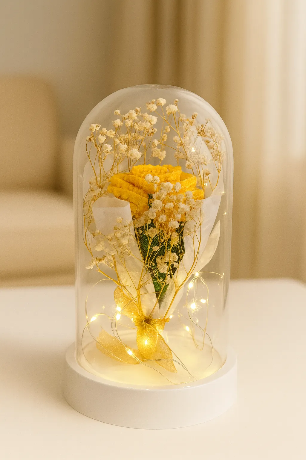 Yellow knitted rose and white gypsophila bouquet inside a glass cloche